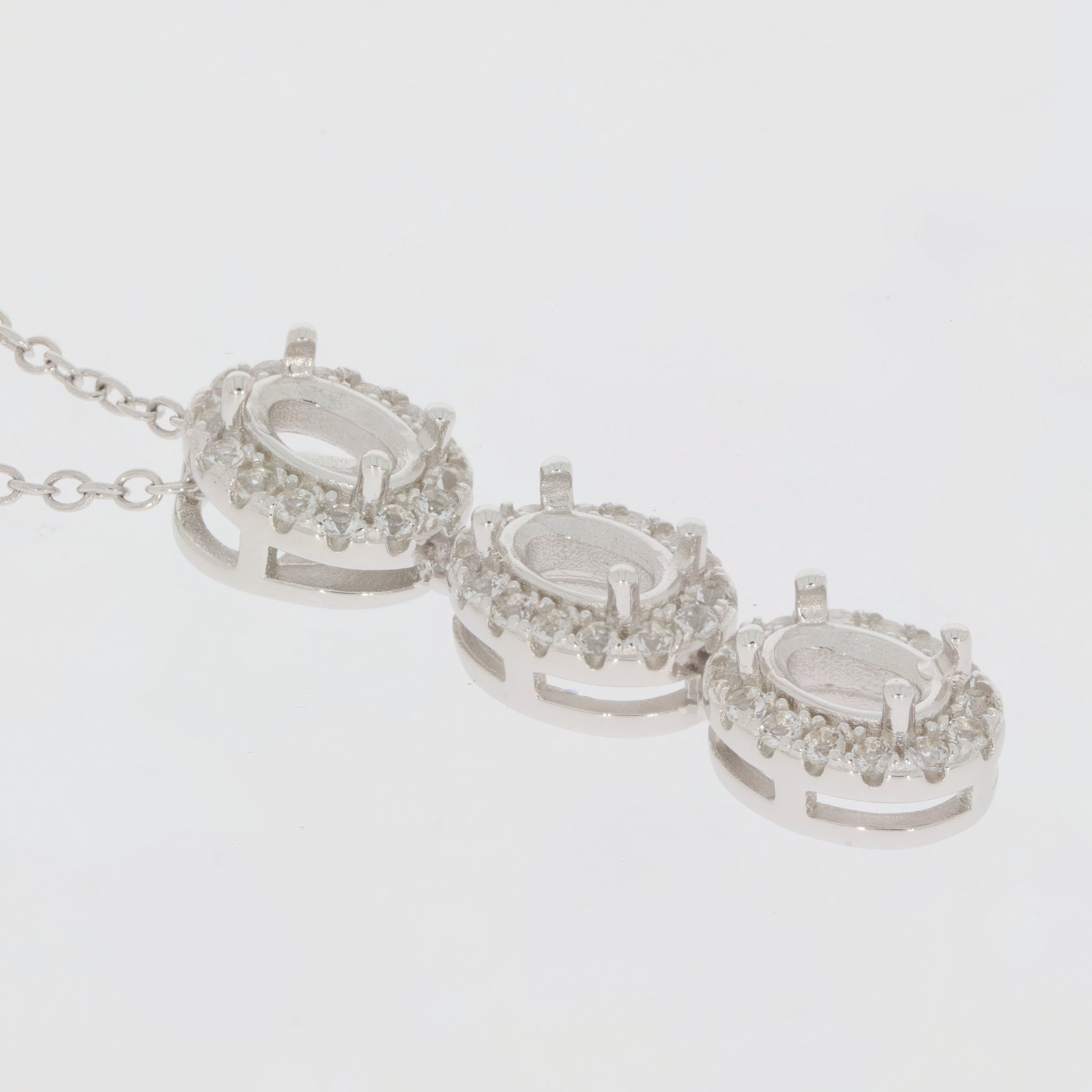 Sterling Silver semi mount pendant setting featuring oval white topaz halo design with three stone arrangement.