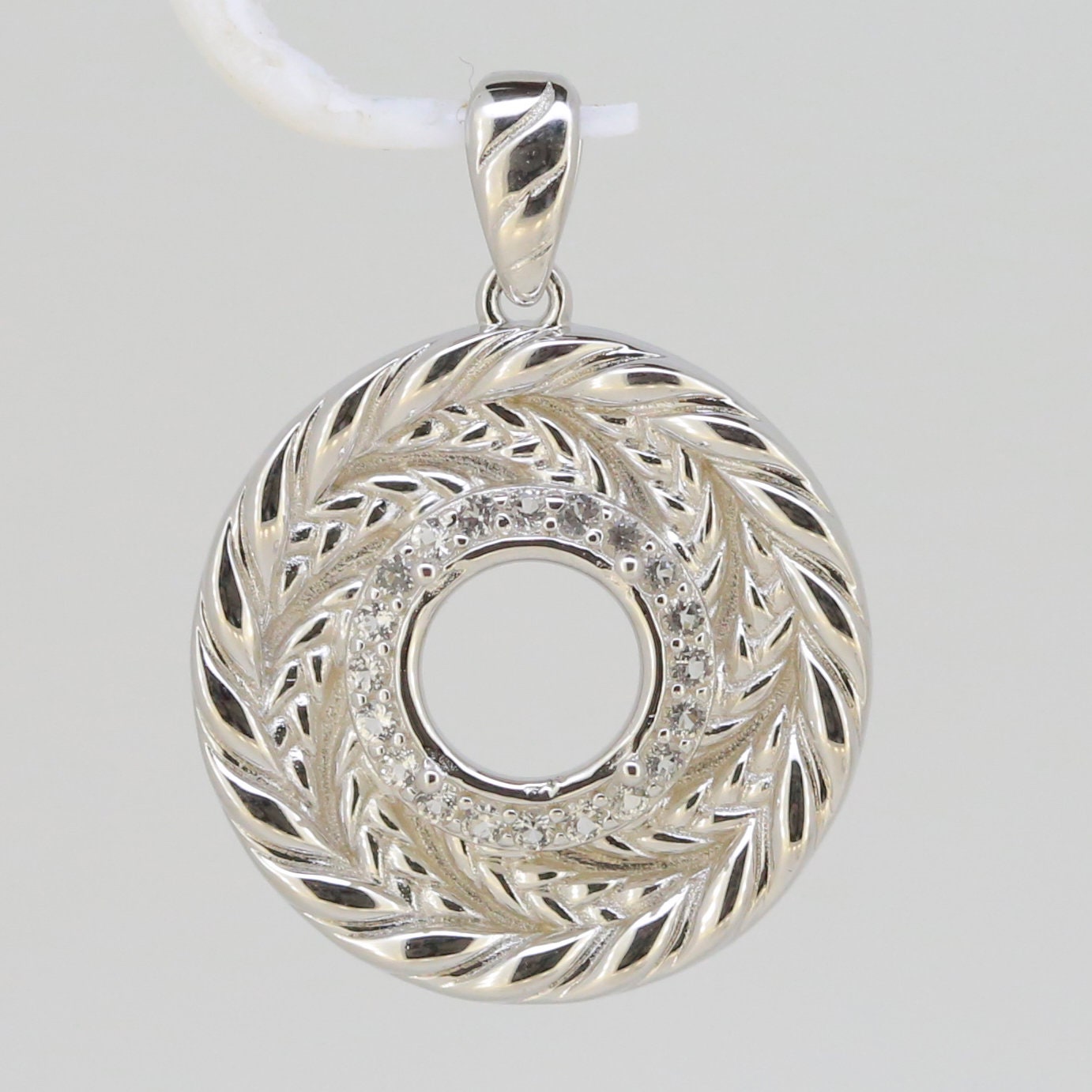 Sterling silver semi mount pendant setting featuring a round halo design with white topaz accents, designed for custom gemstones.