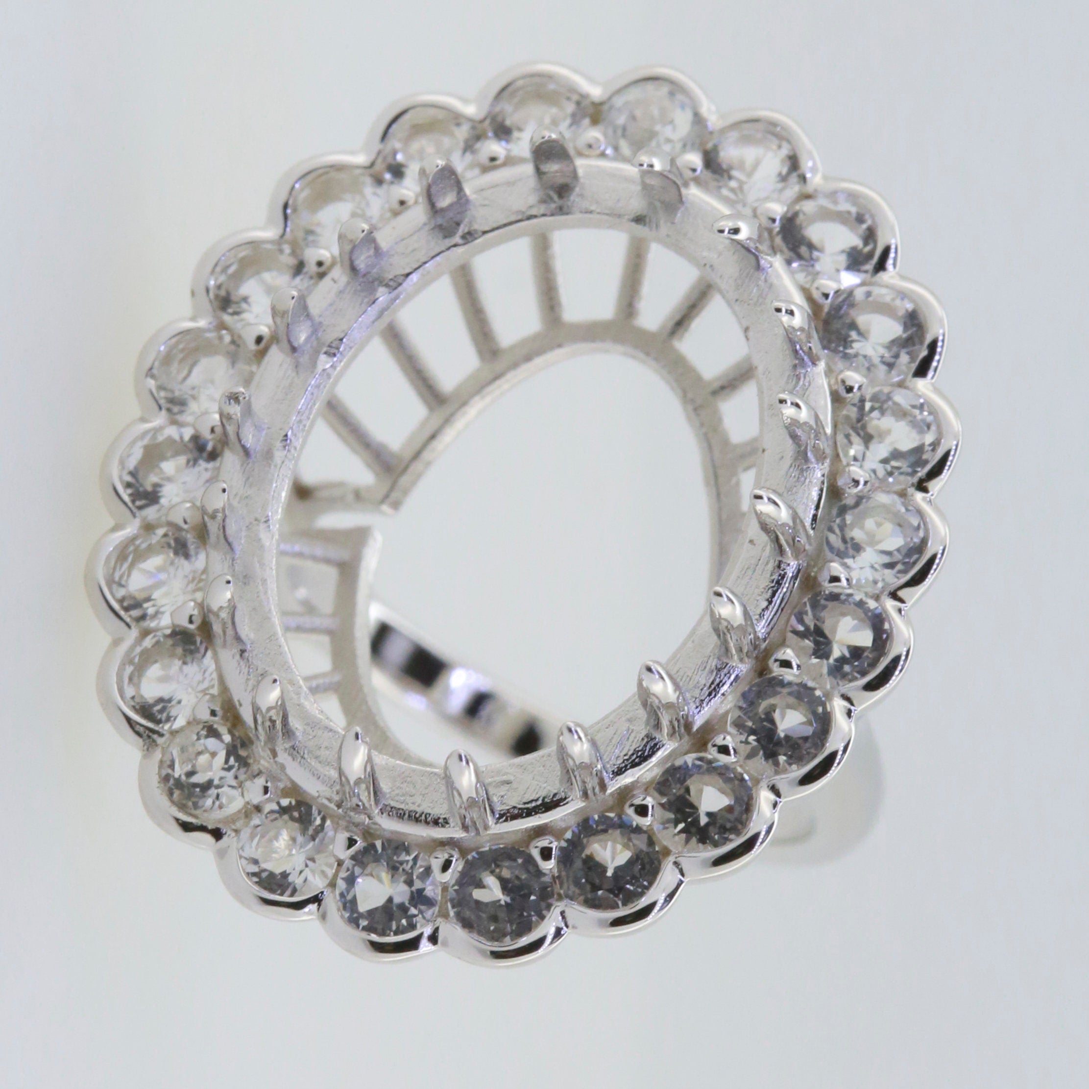 Sterling Silver semi mount ring setting with white topaz halo, designed for custom oval stone placement.