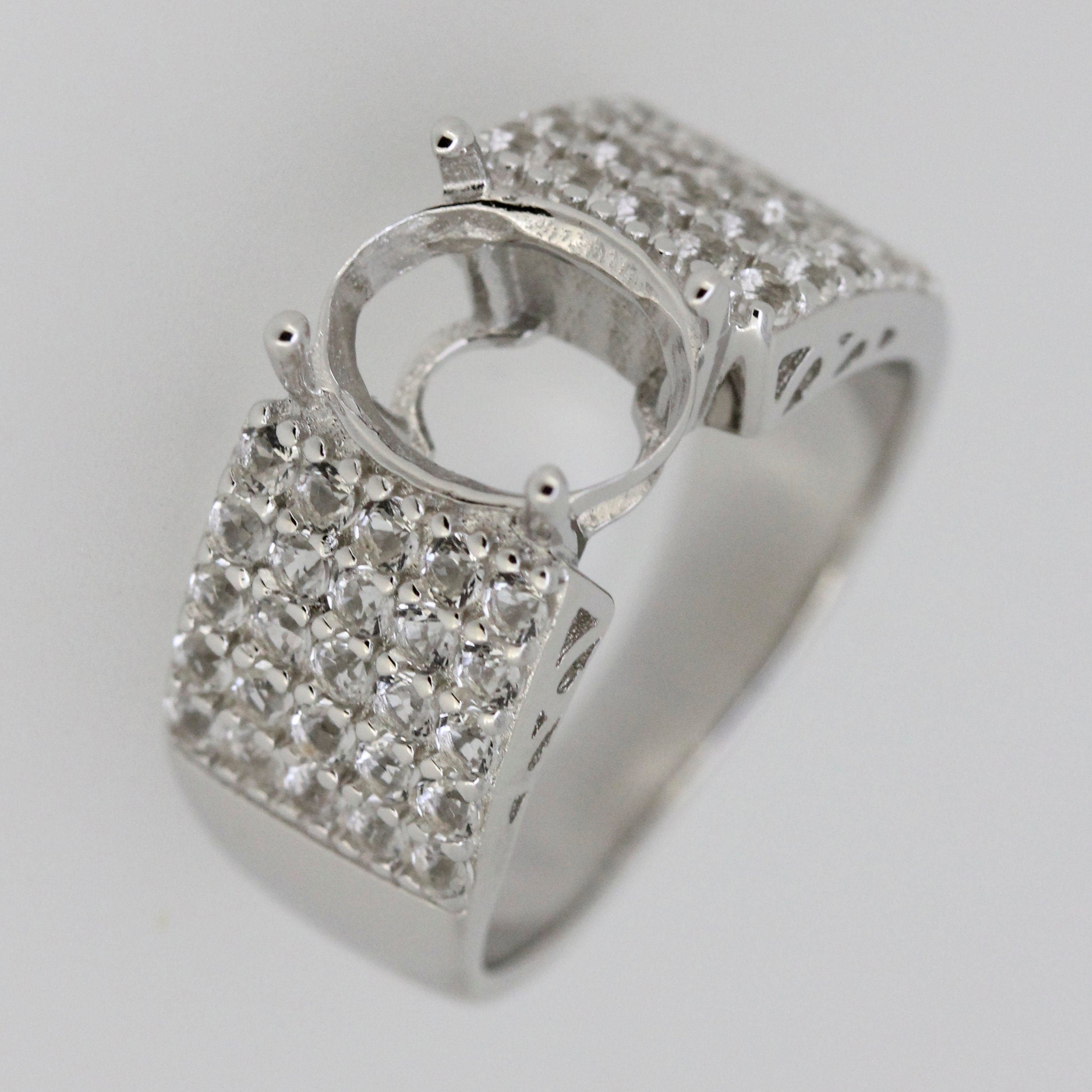 Sterling silver semi mount ring setting with oval stone placeholder and sparkling accents, ideal for custom gemstone.