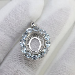 Sterling silver semi mount pendant setting with oval halo featuring aquamarine gemstones.