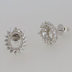 Sterling silver semi mount earrings setting with halo design for 8x6mm oval gemstone, featuring white topaz accents.