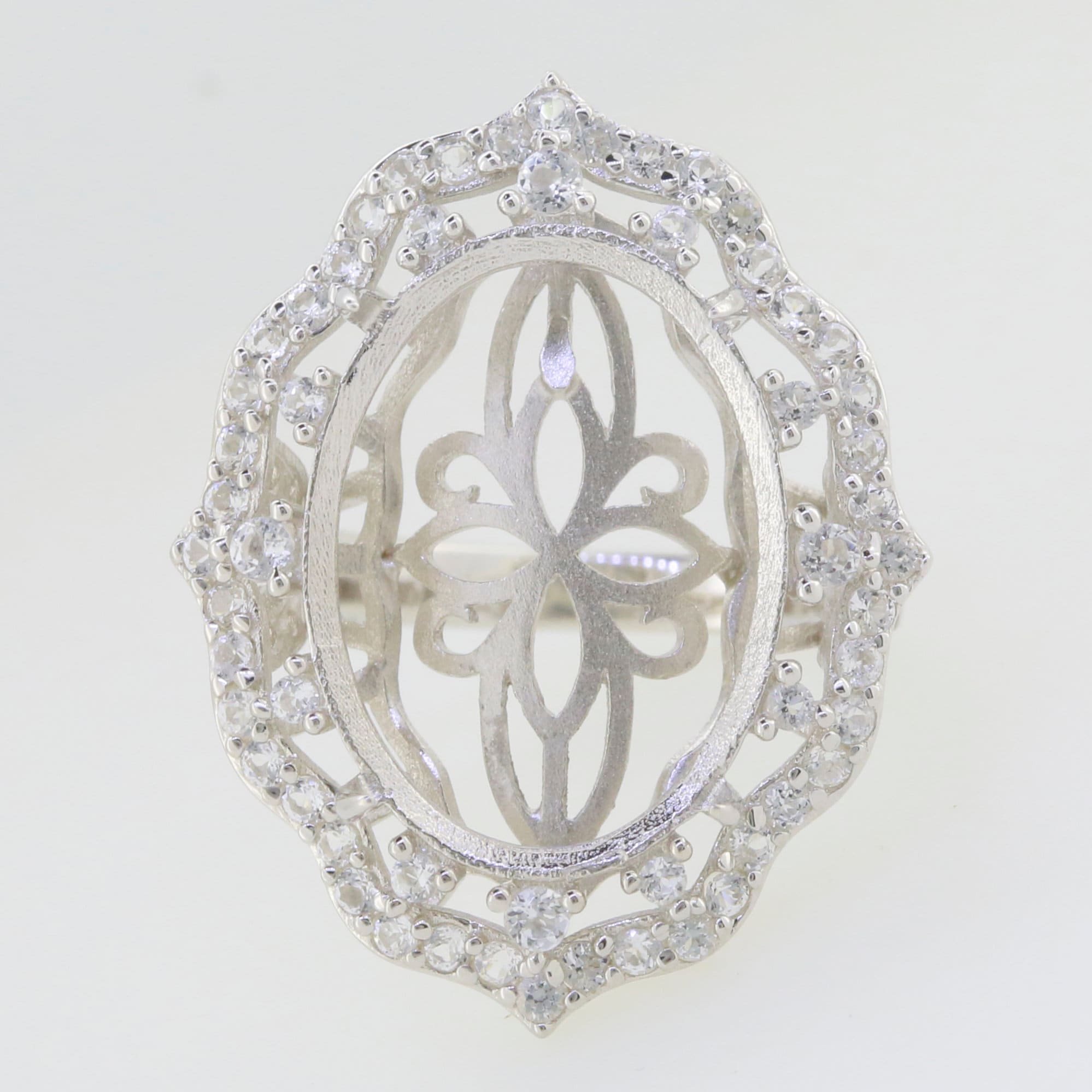 Custom sterling silver semi mount ring setting with oval halo design and moissanite accents.