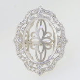 Custom sterling silver semi mount ring setting with oval halo design and moissanite accents.