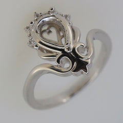 Sterling silver semi mount tiara ring setting with space for 9x6mm pear gemstone and white topaz accents.