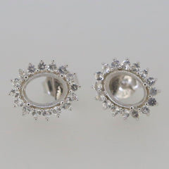 Sterling silver semi mount earrings setting with halo design for oval 8x6mm gemstones, featuring white topaz accent stones.