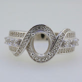 Sterling Silver Twisted Shank Semi Mount Ring Setting with Oval Halo for 8x6mm Gemstone and White Topaz accents.