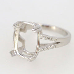 Sterling silver semi mount ring setting with oval bezel for 14x10mm gemstone, featuring split shank and white topaz accents.