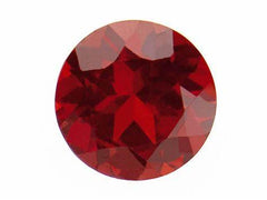 Close-up of a brilliant round red gemstone, showcasing its deep color and faceted surface, ideal for custom jewelry.