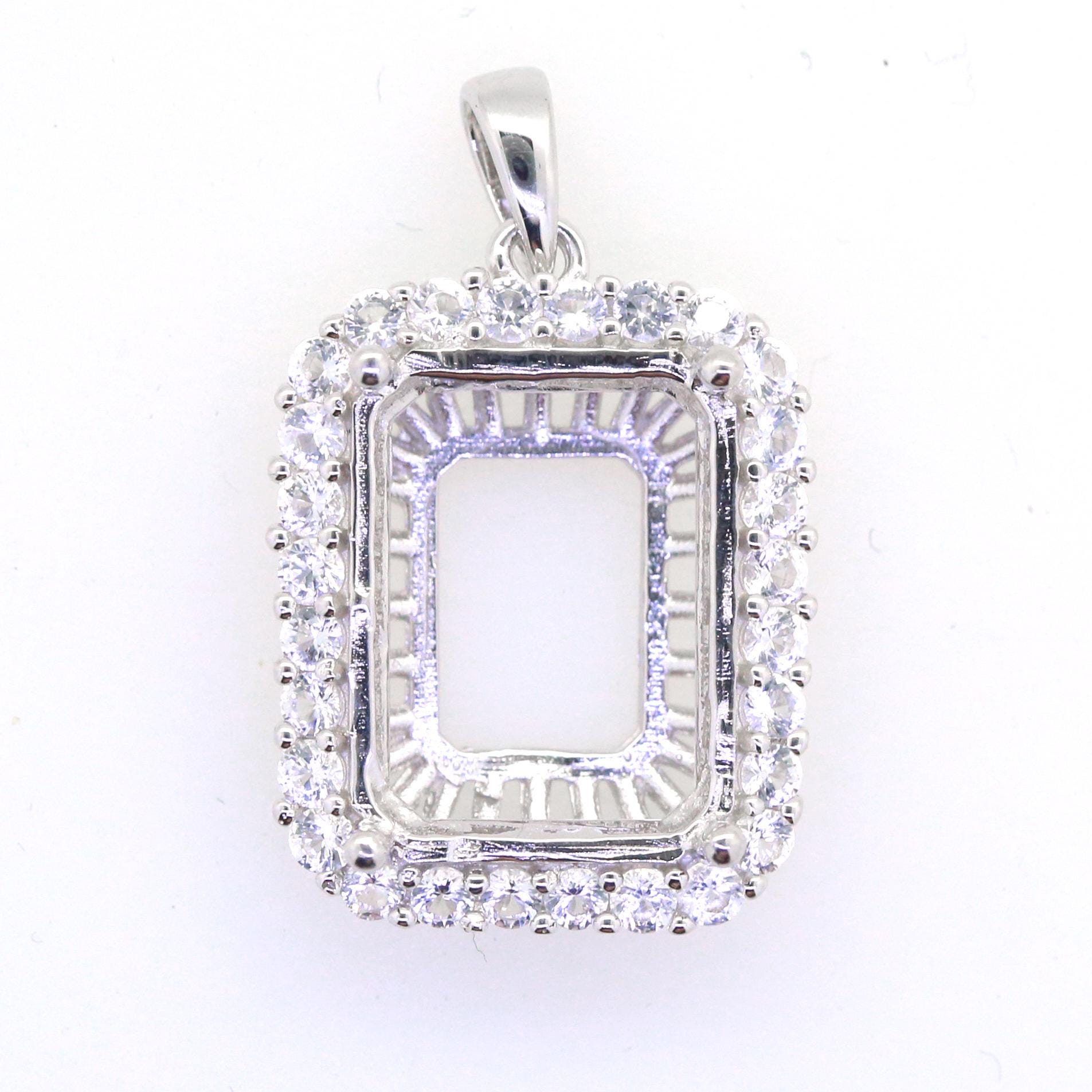 Sterling Silver semi mount pendant setting with white topaz halo, designed for 16x12 emerald gemstones.
