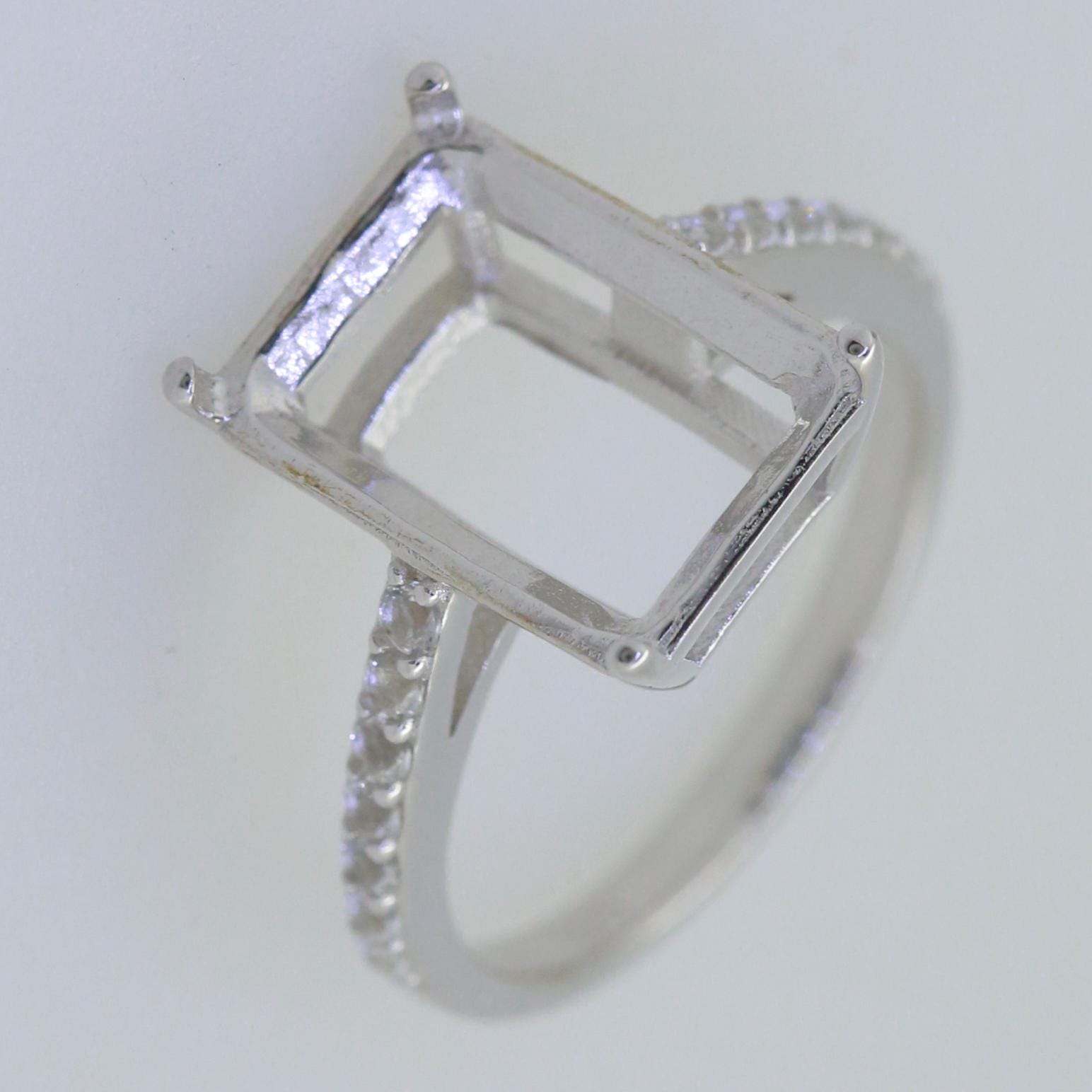 Sterling silver semi mount ring setting for emerald with white topaz accent, ready for custom gemstone fitting.