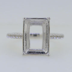Sterling silver semi mount ring setting with an empty rectangular bezel for an emerald gemstone.