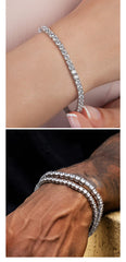 Sterling silver plated CZ tennis bracelet on wrist, showcasing elegance and luxury with sparkling round gemstones.