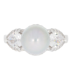 Elegant white pearl sterling silver ring with sparkling gemstones on each side, perfect for a sophisticated jewelry collection.