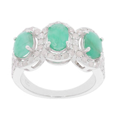 Oval green emerald sterling silver ring with three gemstones and accent stones, showcasing elegant design and luxury.