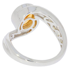 Oval yellow citrine sterling silver ring showcasing intricate design and sparkling moissanite accent.