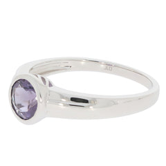 Round silver ring featuring a round purple gemstone, showcasing elegant design and craftsmanship.