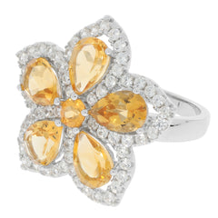 Yellow pear-shaped gemstone flower ring surrounded by sparkling white stones in a silver setting.