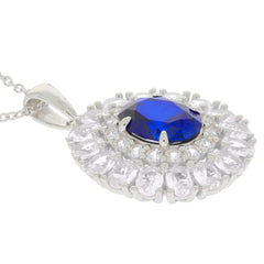 Sterling silver pendant featuring an oval blue sapphire surrounded by sparkling clear stones, elegant jewelry piece.
