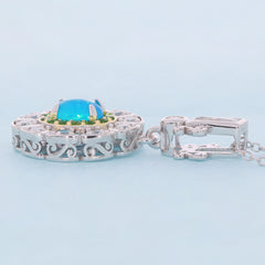 Oval blue opal sterling silver pendant featuring intricate detailing and an elegant design, perfect for sophisticated style.