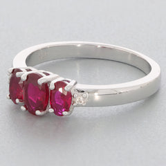 Red Ruby Sterling Silver Ring featuring three oval rubies and accent stones, perfect for a luxurious touch.
