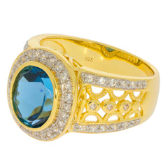 Elegant gold ring featuring a large oval blue topaz gemstone surrounded by sparkling accents.