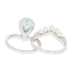 Pear blue topaz sterling silver ring with moissanite accent and pearl details, showcasing elegance and luxury.