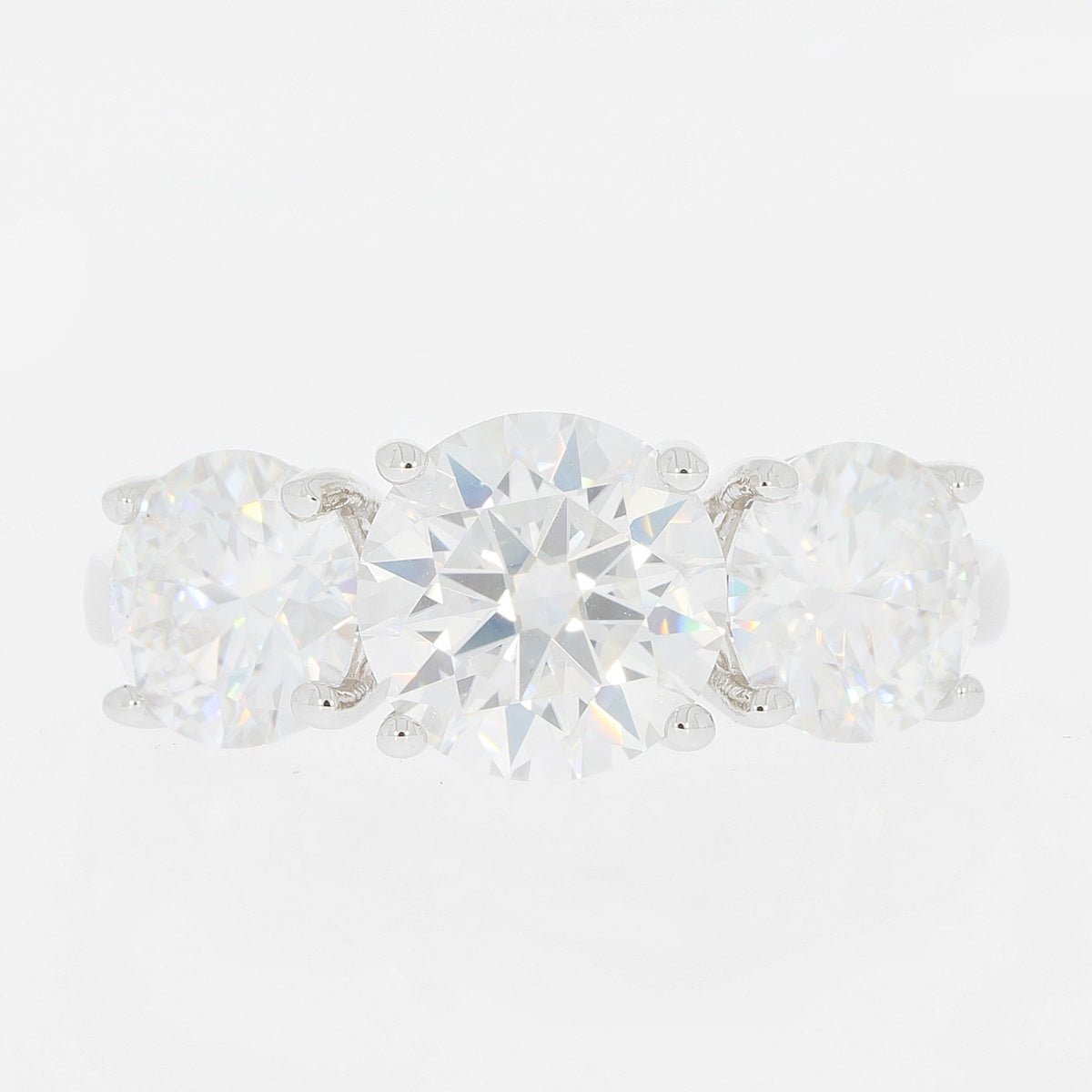 Elegant three-stone ring featuring brilliant round cut diamonds set in white gold, perfect for any occasion.