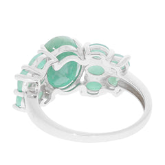 Elegant oval green emerald sterling silver ring showcasing intricate design and sparkling accents from the side.