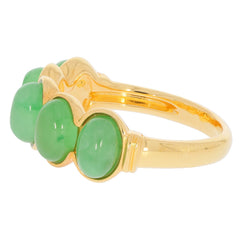 Elegant gold ring featuring three green jade gemstones, showcasing luxury and sophistication.