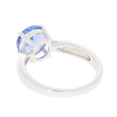 Round blue tanzanite sterling silver ring showcasing a sparkling gemstone from the side view.