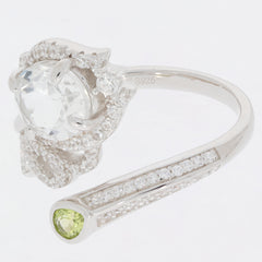 Oval green peridot sterling silver ring with moissanite accent, featuring sparkling gemstones and elegant design.