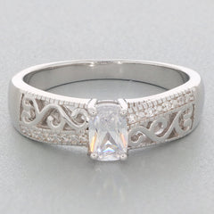 Cushion cut moissanite sterling silver ring with elegant filigree design and accent stones.