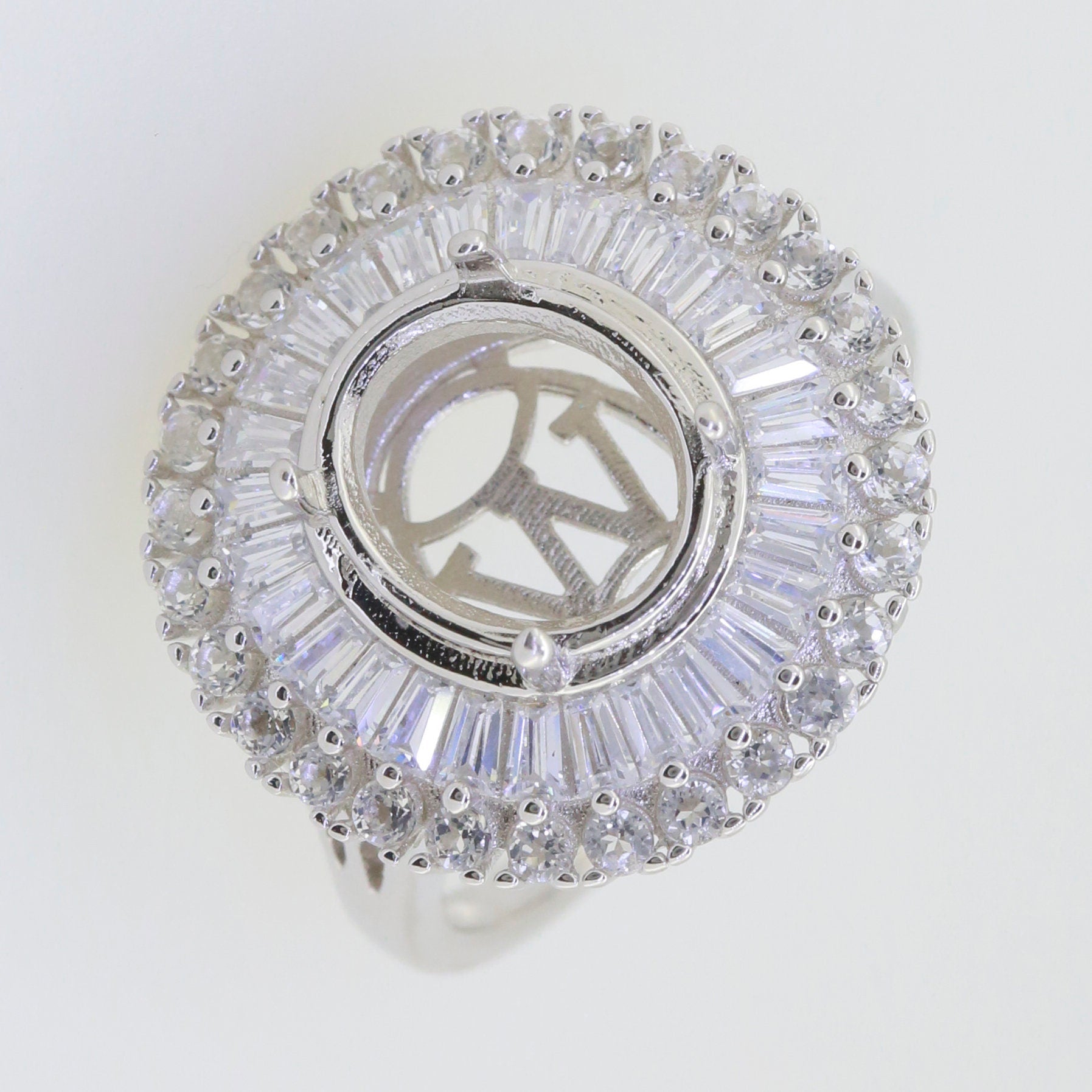 Sterling silver semi mount ring setting with oval halo of white topaz and baguette gemstones, main stone not included.