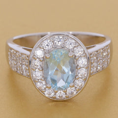 Sterling silver semi mount ring setting with oval blue topaz and halo of white topaz stones, elegant design.