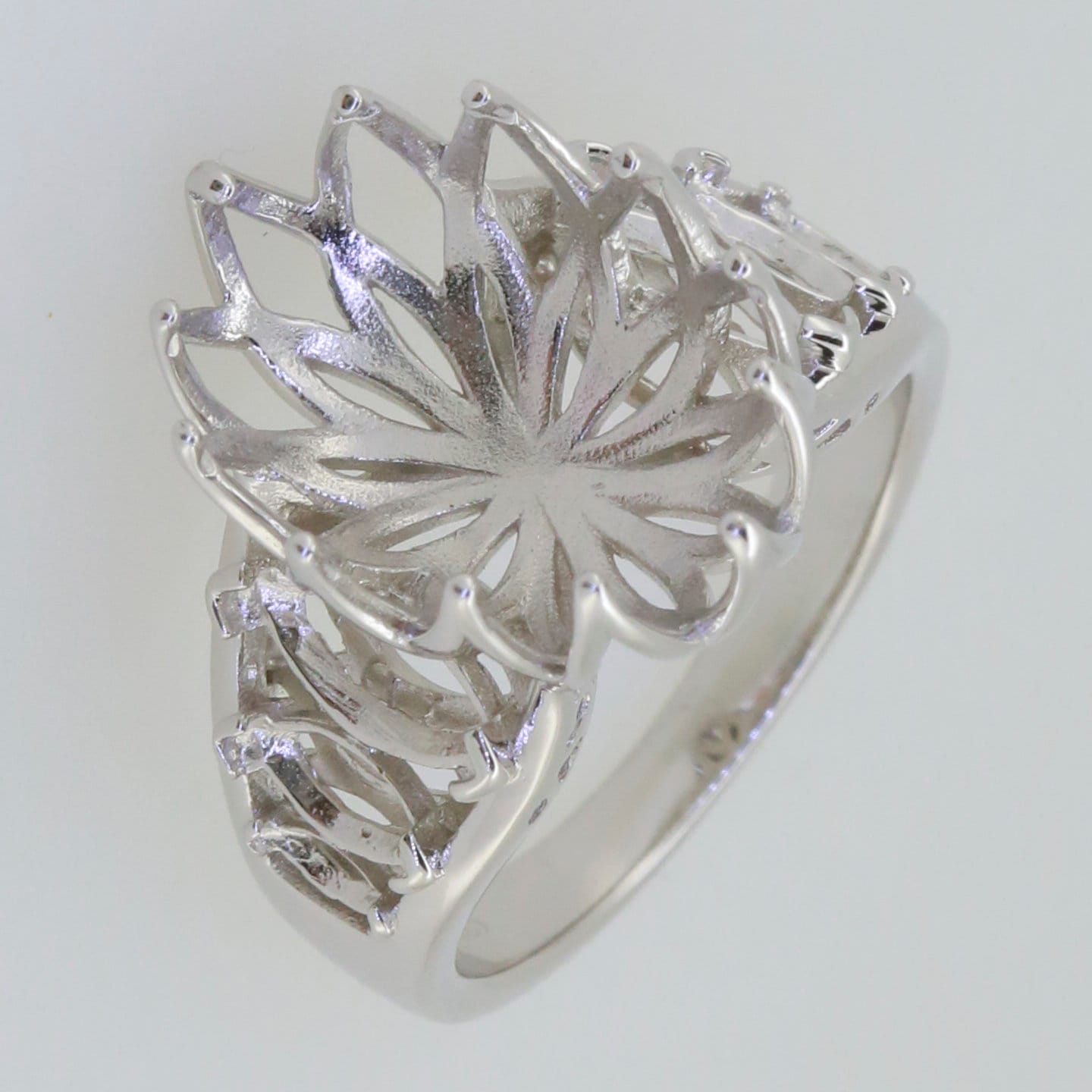 Sterling silver semi mount ring setting featuring an intricate floral design, designed for oval gemstones.
