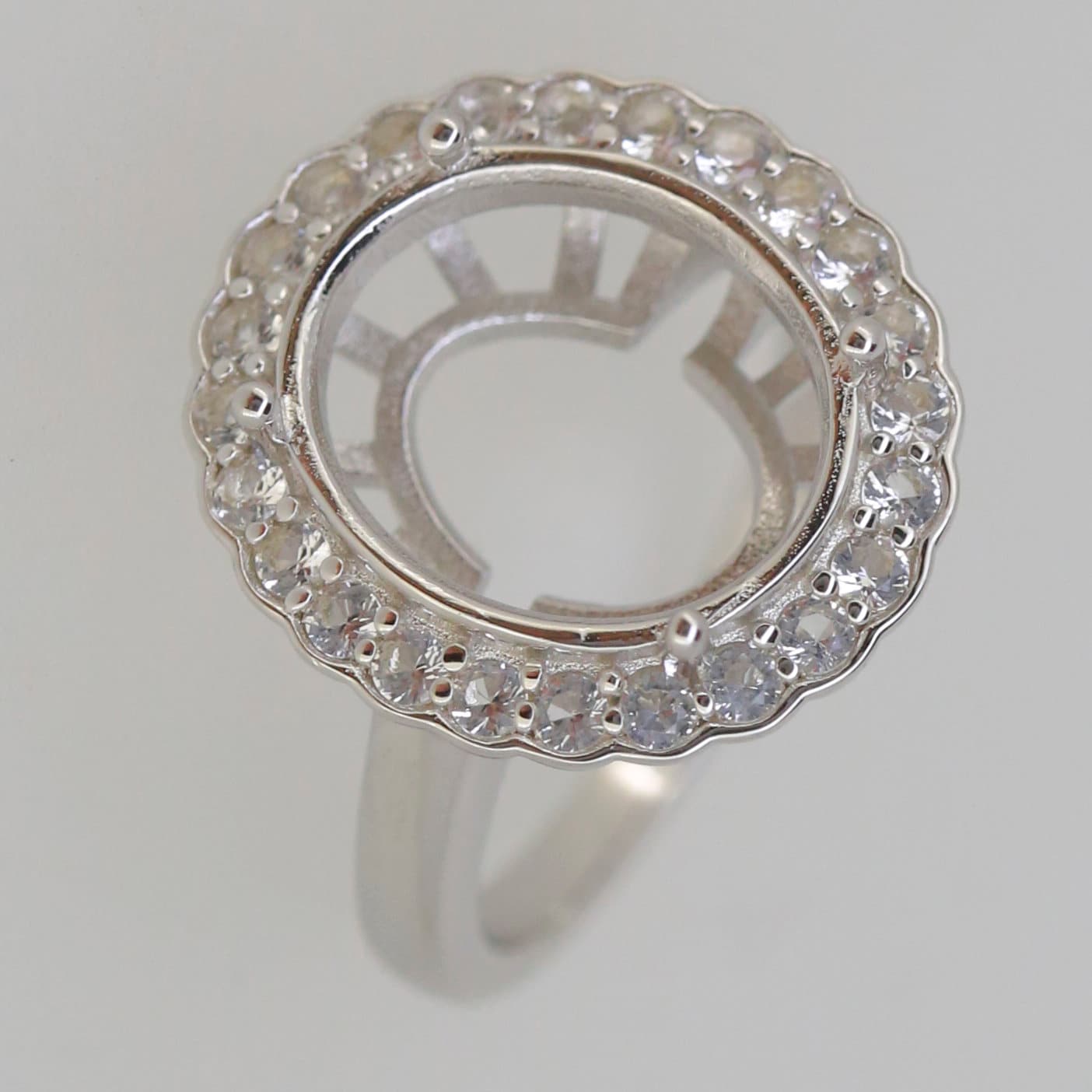 Sterling silver semi mount ring setting with halo and moissanite accents for oval gemstone 14x12mm.