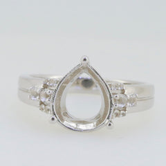 Sterling silver semi mount ring setting with white topaz accents, featuring a pear-shaped center for customizable gemstones.