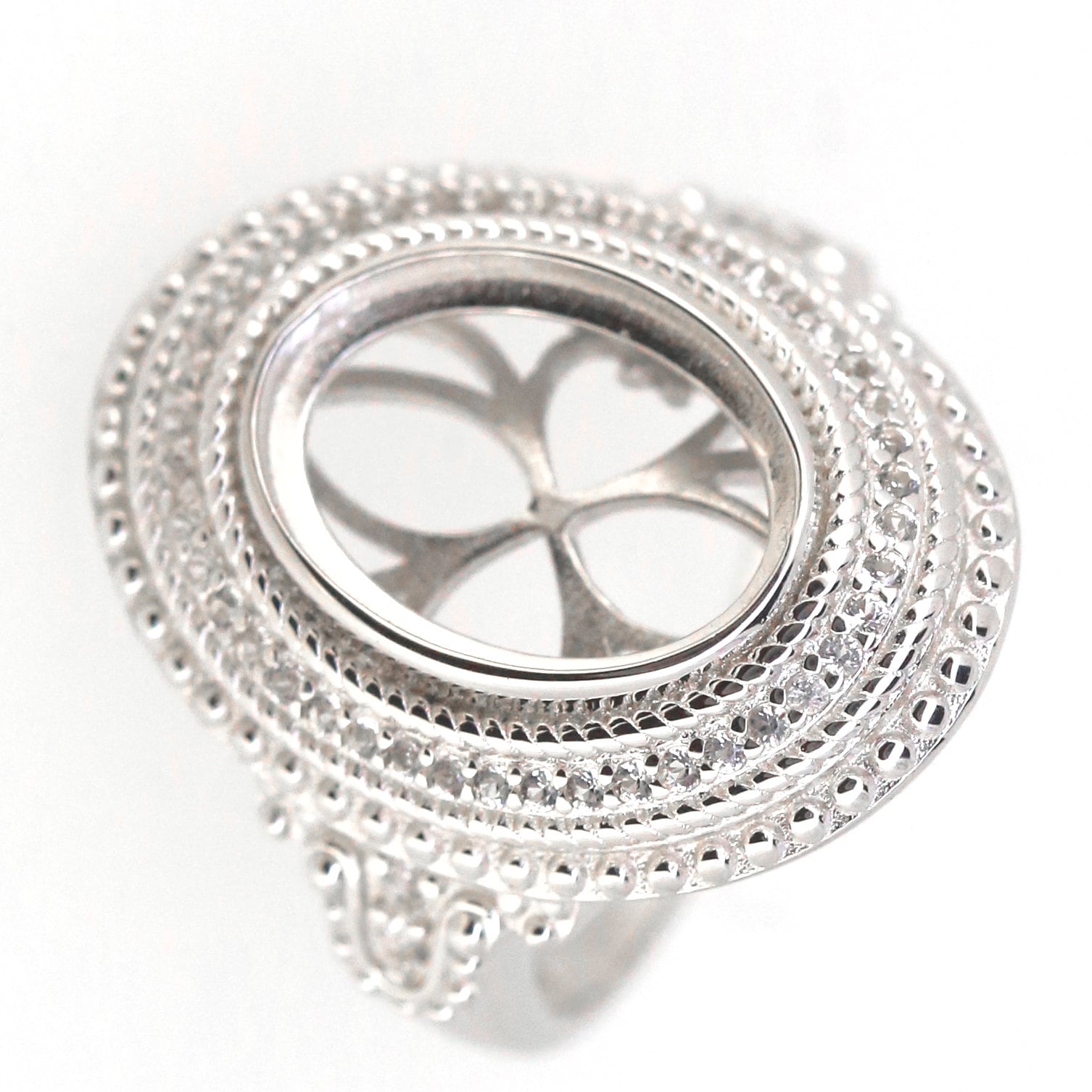 Sterling silver semi mount ring setting with halo design for 11x9mm oval cabochon, featuring intricate milgrain detail.