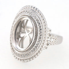 Sterling silver semi mount ring setting with oval cabochon design and halo milgrain detail, featuring white topaz gems.