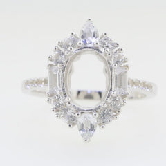 Sterling silver semi mount ring setting with oval halo design, showcasing white topaz gem accents and baguette details.