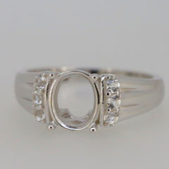 Sterling silver semi mount ring setting with oval 9x7mm space and D color moissanite accents.