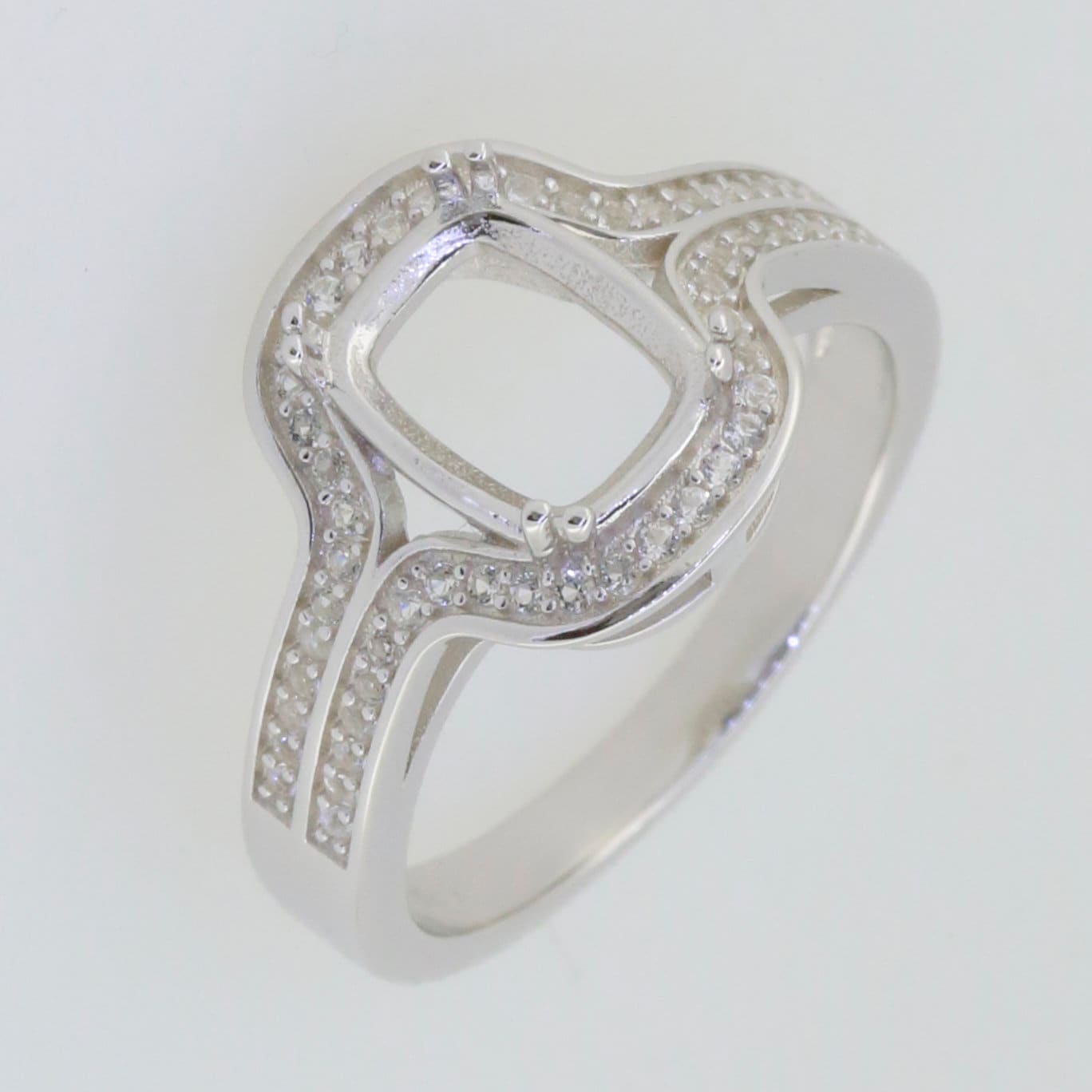 Sterling silver semi mount ring setting with cushion center, white topaz halo, and split shank design.