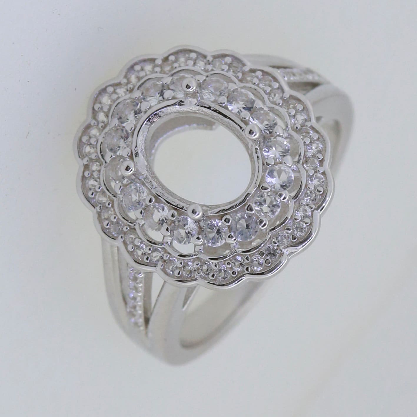 Sterling Silver Semi Mount Ring Setting with Double Halo design and space for Oval gemstone, adorned with White Topaz accents.