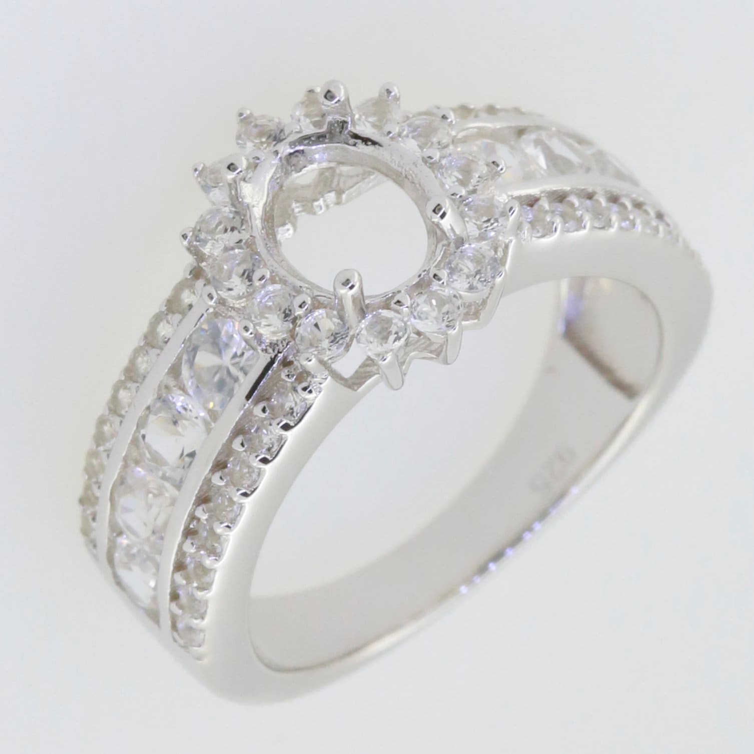 Sterling silver semi mount ring setting with halo and moissanite accents for 8x6mm oval gemstone.