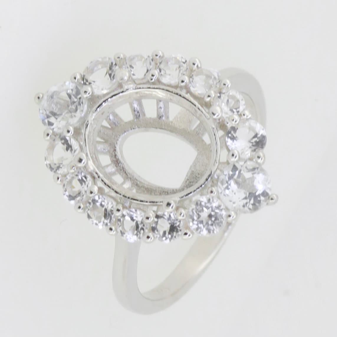 Sterling silver semi mount ring setting with halo of moissanite accents, designed for a 9x7mm oval gemstone.