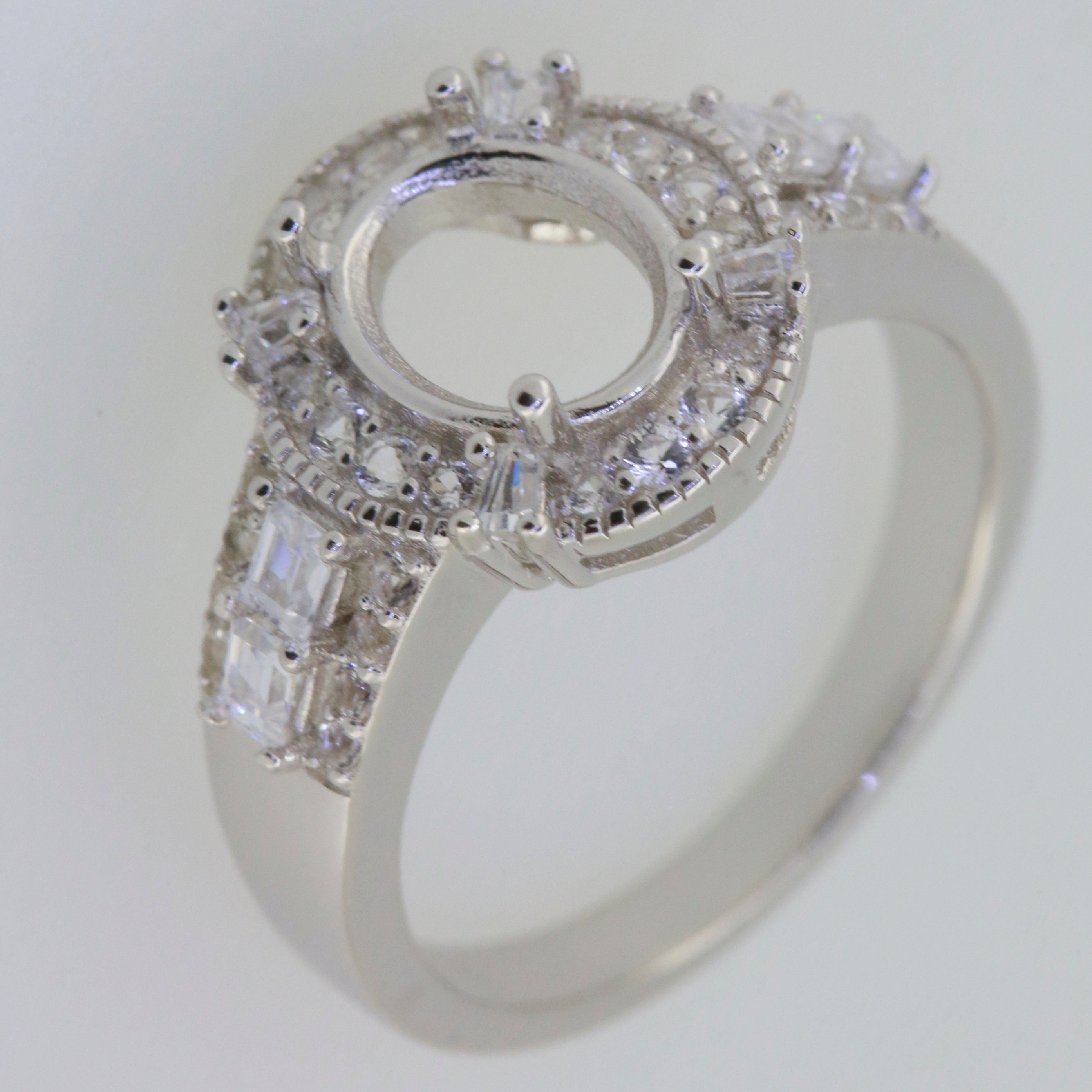 Sterling silver semi mount ring setting with oval halo and baguette stones, designed for customizable gemstones.