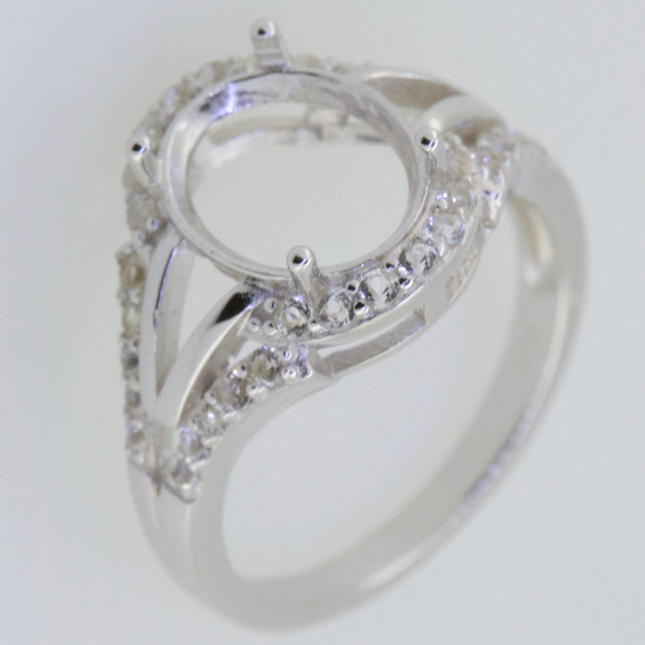 Sterling silver semi mount ring setting with moissanite accent, designed for 10x8mm oval gemstone.