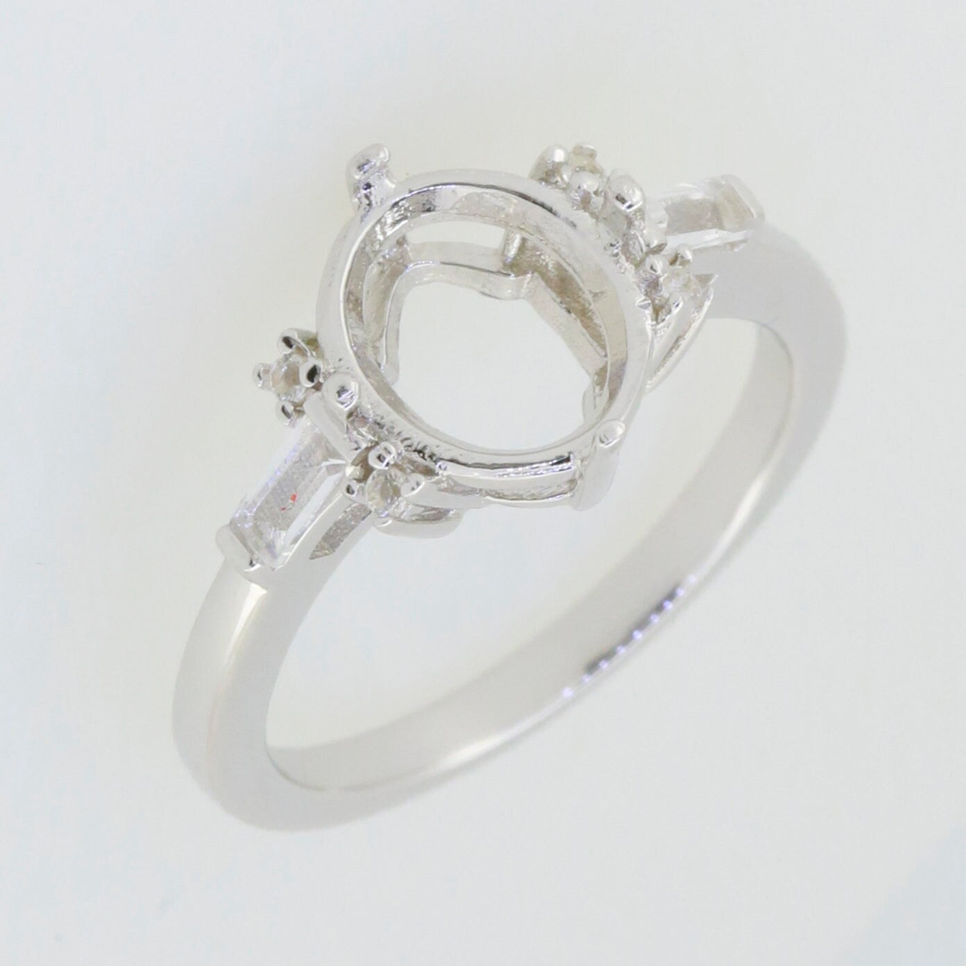 Sterling silver semi mount ring setting with oval shape for 10x8mm gemstone and baguette accents.