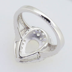 Sterling Silver semi mount ring setting with pear shape, split shank halo design, featuring white topaz accent.